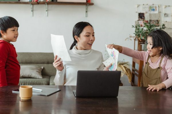 Canva - Modern working mother looking at pictures of kids at home
